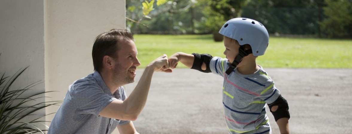 Father and son bumping fists, smiling